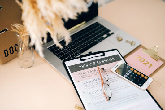 Pricing worksheet, calculator and laptop used to calculate transparent fixed prices for digital services