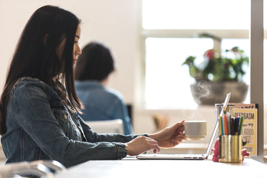 Coffee and laptop on a work table representing a free 20-minute Mind the Shop business call